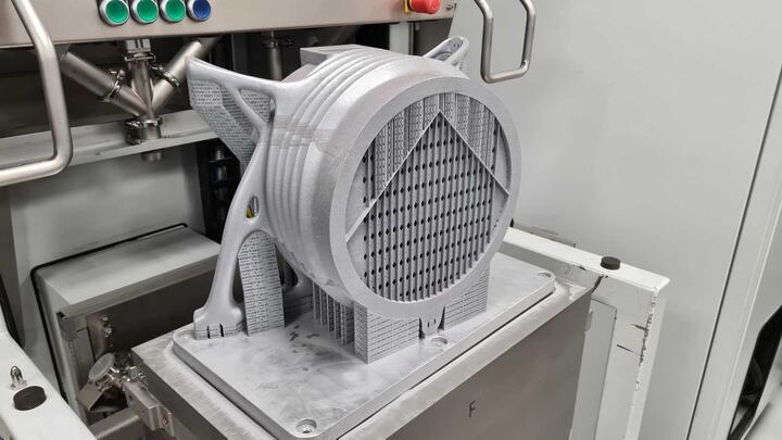 The 3D printed aluminium motor casing on the build plate, as-built with support structures.