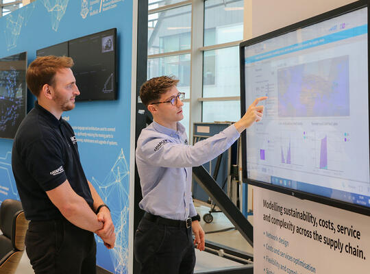 Two people looking over a digital dashboard